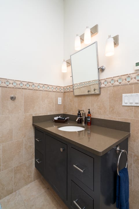 Modern bathroom with a stylish vanity, decorative tiles, and frosted glass lighting.