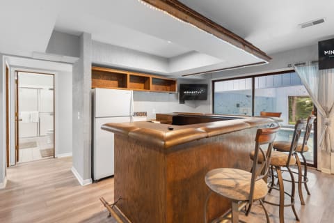 Interior view of a kitchen showcasing a wooden bar and high stools