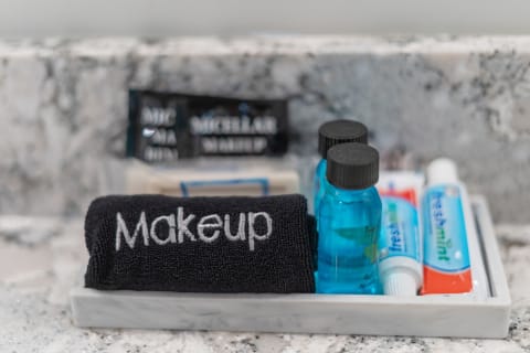 A tray containing a black towel labeled 'Makeup', blue makeup remover bottles, and tubes of toothpaste.
