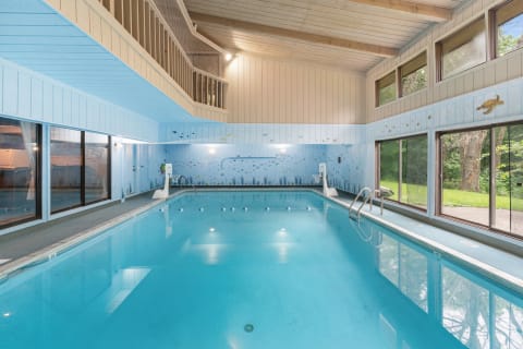 Indoor swimming pool with clear water and colorful fish murals on the walls.
