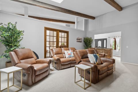 Living room with brown leather recliners, small side tables, and decorative elements.