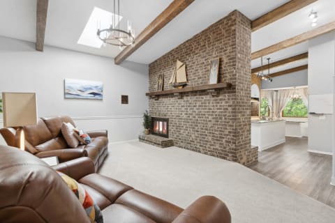 Inviting living room with brown leather sofas and a brick fireplace.