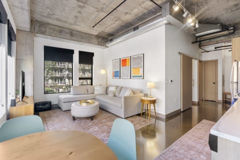 Modern living room with a sectional sofa, artwork, and dining area.