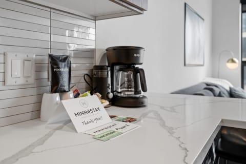 Kitchen countertop featuring a coffee maker, a thank-you note, and a stylish decor.