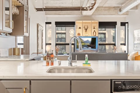 Modern kitchen featuring marble countertops and a cozy living space with a view.