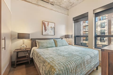Modern bedroom with king-sized bed and decorative lamps.