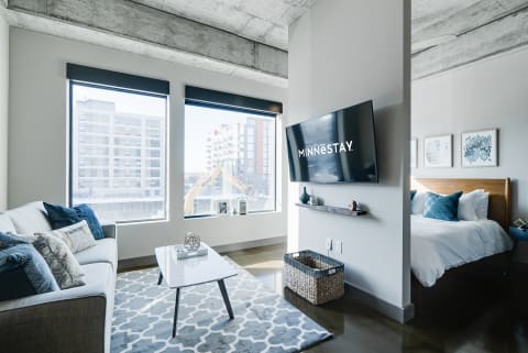 Contemporary living room with a cozy sofa, coffee table, and exposed concrete ceiling.