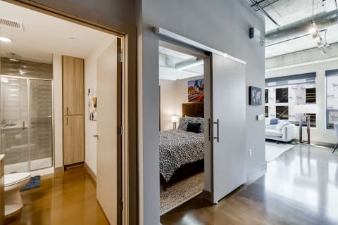 Modern studio apartment interior showing bedroom and bathroom.