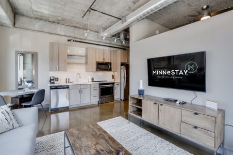 Stylish living room with kitchen and dining area in an industrial design apartment.