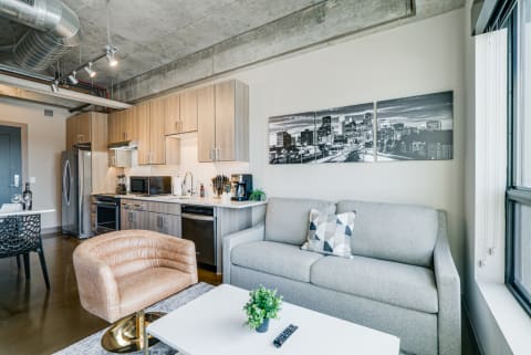 Contemporary apartment interior with a kitchen and living area, featuring modern furniture and decor.