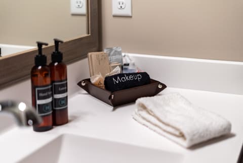 Organized bathroom countertop with amber bottles, a makeup towel, and a folded white towel.
