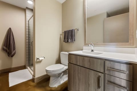 Contemporary bathroom featuring a white vanity, glass shower, and polished floor.