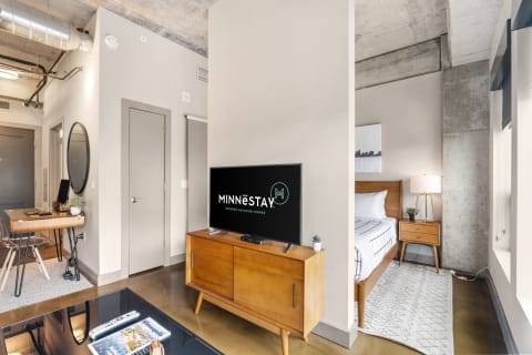 A stylish interior of a modern apartment featuring a living area and partially visible bedroom.