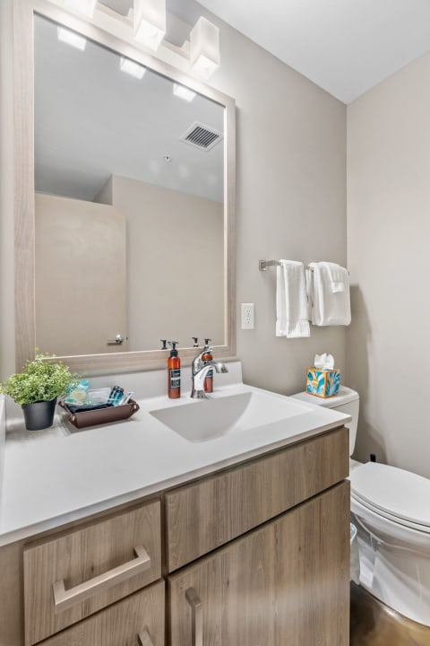 Modern bathroom featuring a white countertop, chrome faucet, and decorative elements.