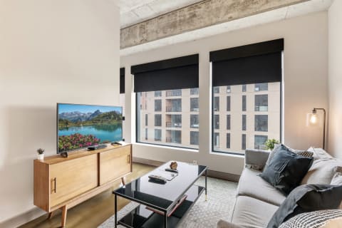 Modern living room with a television displaying a mountain landscape and stylish furniture.
