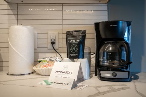 Coffee machine with supplies and hospitality cards on a countertop.