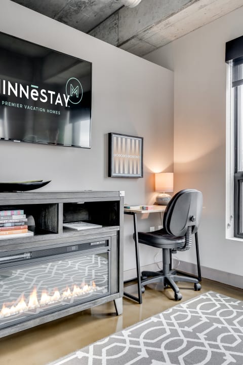 Modern living space with a TV, fireplace, and workspace.