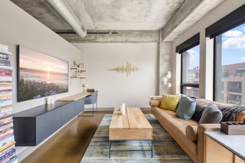 Modern living room with a concrete ceiling, stylish furniture, and bright city views.