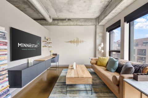 Modern living room with a leather sofa, wooden coffee table, and large window.