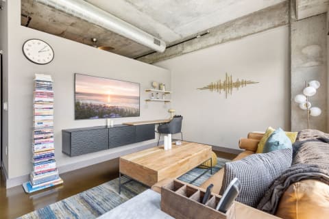 Modern living room featuring a sofa, coffee table, TV, and decorative elements.