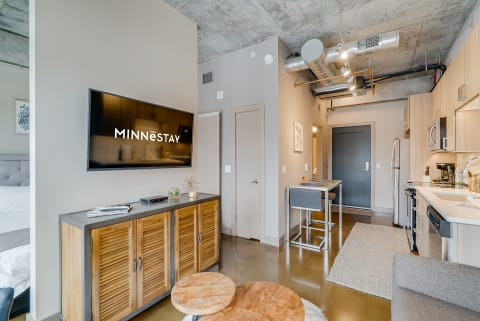 Interior view of a contemporary studio apartment with a kitchenette and cozy seating area.