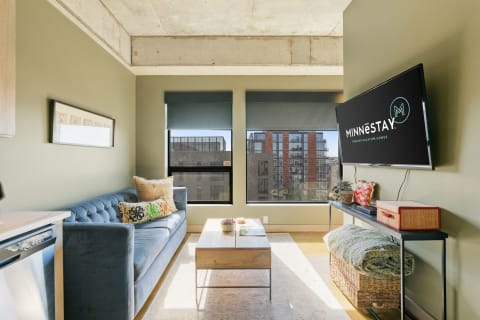 Stylish small living area with blue sofa, modern decorations, and large windows.