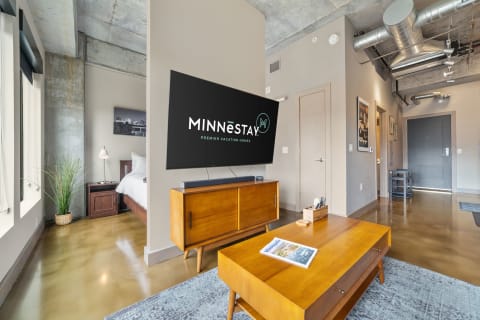 Interior of a modern apartment featuring a stylish living area and branding for MINNēSTAY.