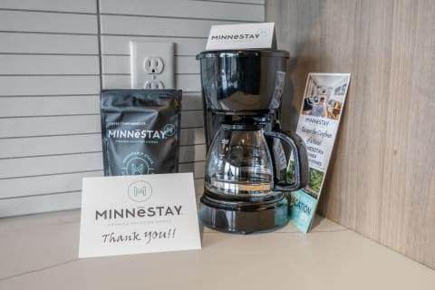 Coffee maker, coffee packet, and a thank-you card from Minnestay on a kitchen countertop.