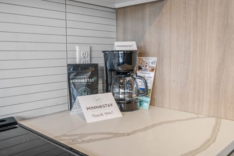 Modern kitchen countertop with a coffee maker, coffee bag, and thank you card.