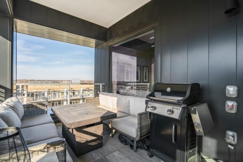 Modern balcony view with seating and grill.