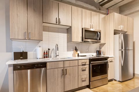 Contemporary kitchen featuring wooden cabinets, stainless steel appliances, and a stylish backsplash.