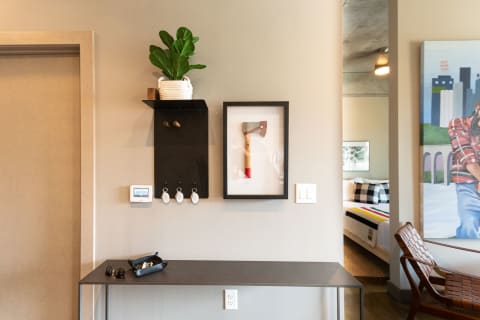Modern entryway with a console table, plant, axe art, and decorative items.