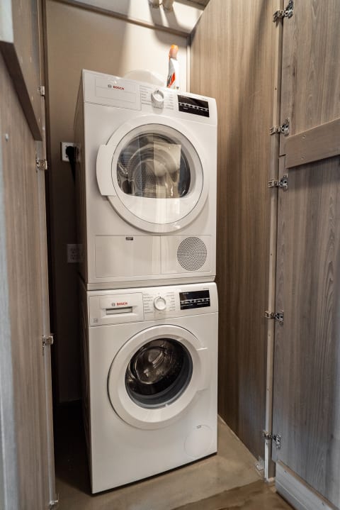 Compact laundry area with a stacked Bosch washer and dryer.