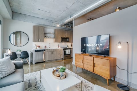 Contemporary living room with a kitchen and modern furniture.