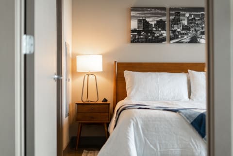 Inside view of a modern bedroom with wooden furniture and a lamp.