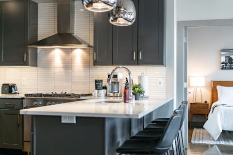 A stylish modern kitchen with dark cabinets and a contemporary island.