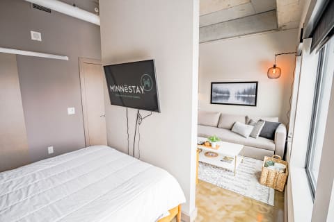 A contemporary studio apartment with a bed and living room space.