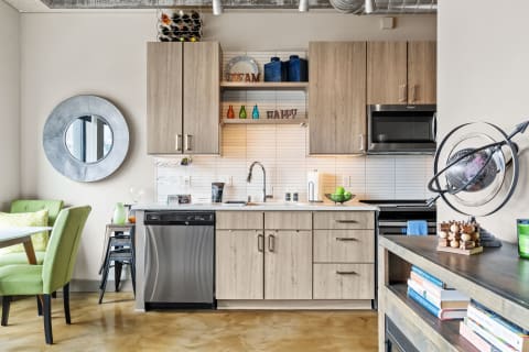 Stylish kitchen with wood cabinets, decorative elements, and a green chair.