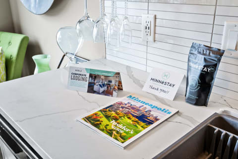 Kitchen counter with lodging brochures, a coffee package, and an insider's guide magazine about Minneapolis.