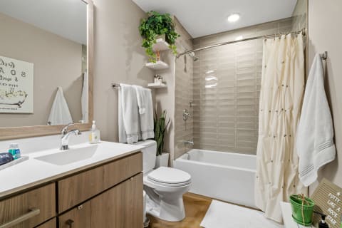 Modern bathroom featuring neutral colors, wooden cabinets, and a stylish shower area.