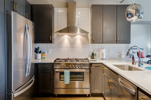 Modern kitchen featuring stainless steel appliances and gray cabinetry.