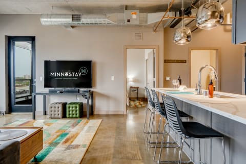 Modern living space with a sleek design, featuring a living area and kitchen bar.