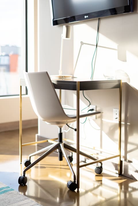 A contemporary desk and ergonomic chair in a well-lit room with modern decor.