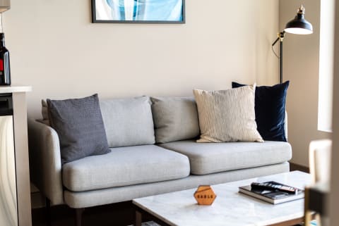 A contemporary living room with a gray sofa, decorative pillows, and a marble coffee table.