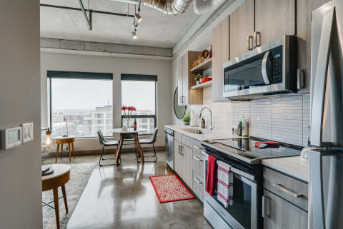 Modern kitchen featuring sleek appliances and a city skyline view.