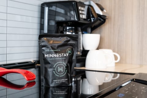 A black coffee bag labeled 'MINNESTAY' in a contemporary kitchen.