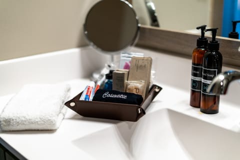 Organized bathroom counter with a brown leather organizer, toiletries, and a white towel