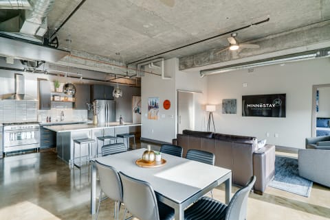 A modern apartment interior with a sleek kitchen, dining area, and living space.