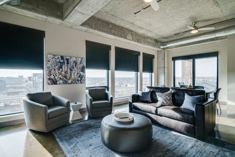 Modern living room featuring exposed concrete ceiling, large windows, and contemporary furniture.