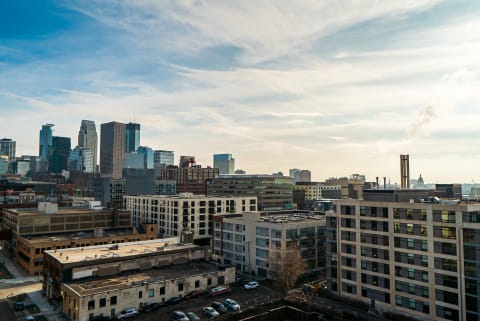 Panoramic view of a city skyline with various buildings and a blue sky.